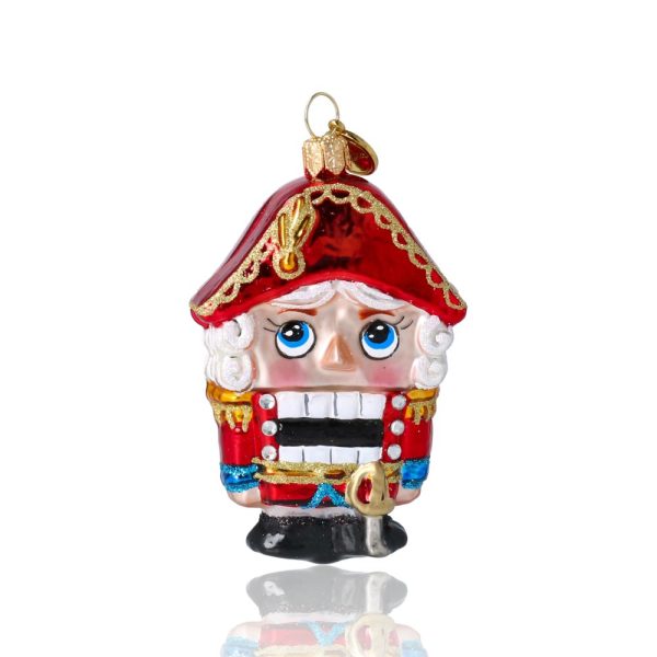 Ёлочная игрушка в виде Щелкунчика в красной униформе.