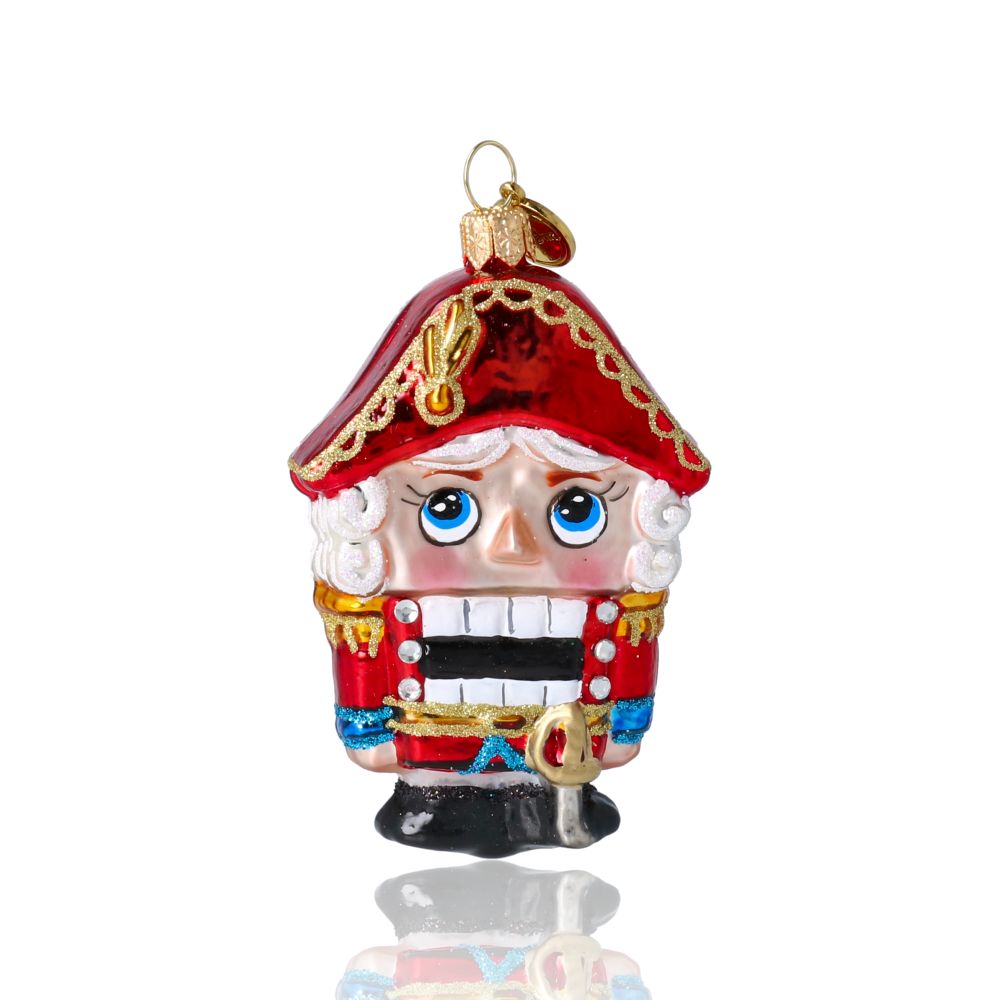 Ёлочная игрушка в виде Щелкунчика в красной униформе.