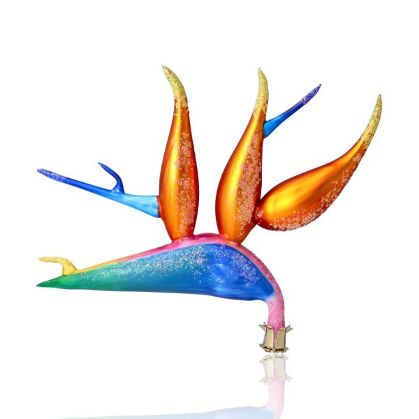 Декоративное украшение в виде яркого абстрактного предмета с разноцветными элементами и блестками на белом фоне.