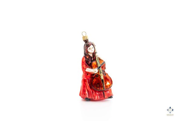 Новогодняя игрушка в виде женщины в красном платье, играющей на виолончели.