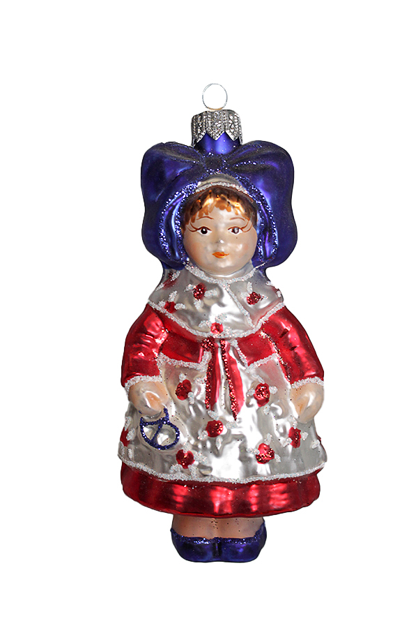 Ёлочная игрушка в виде куклы в красно-белом наряде и синем головном уборе.